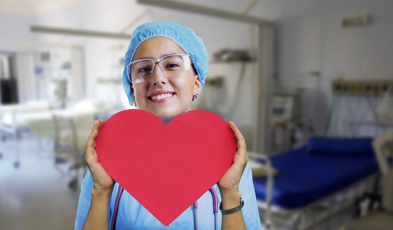 A nurse listening to a patient's heart with a stethoscope during a cardiovascular checkup
