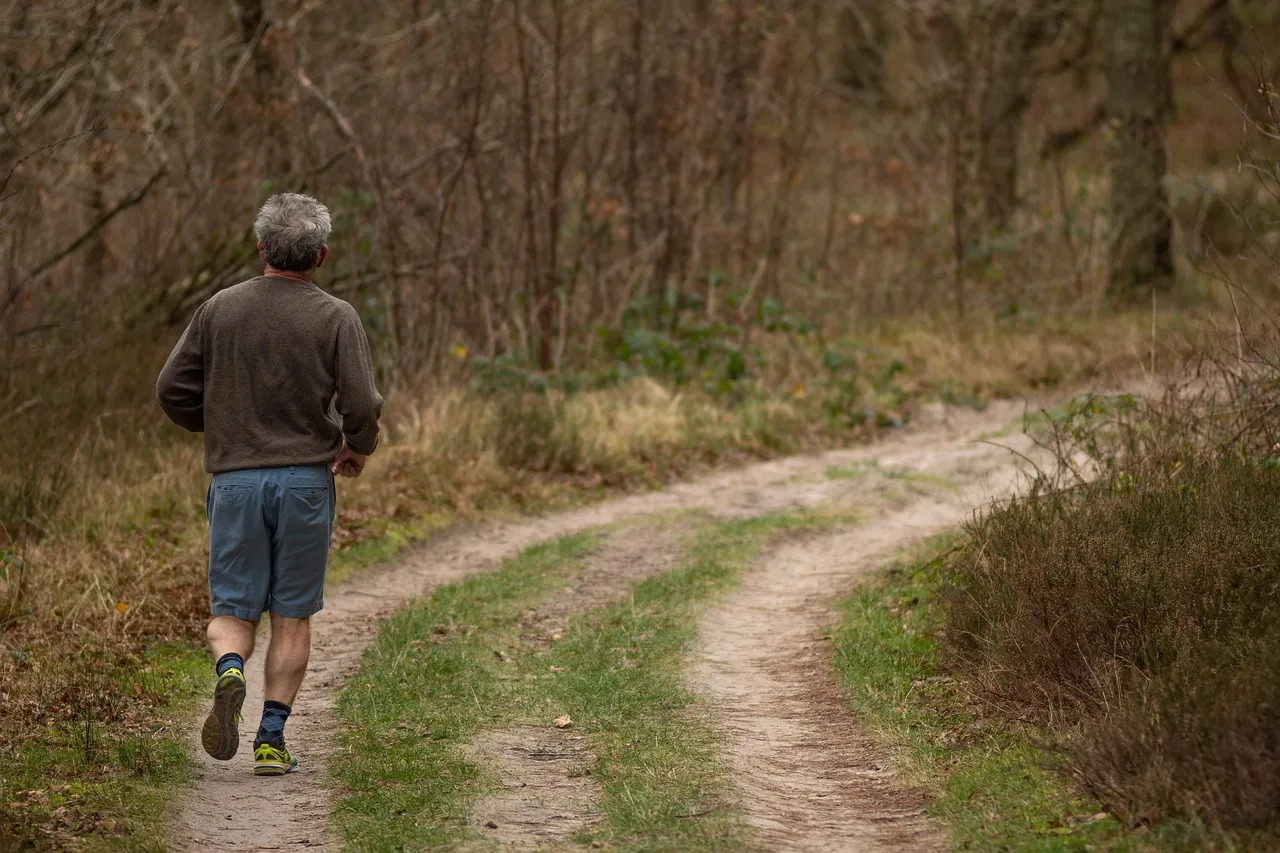 An older adult jogging along a forest trail as part of an active recovery routine
