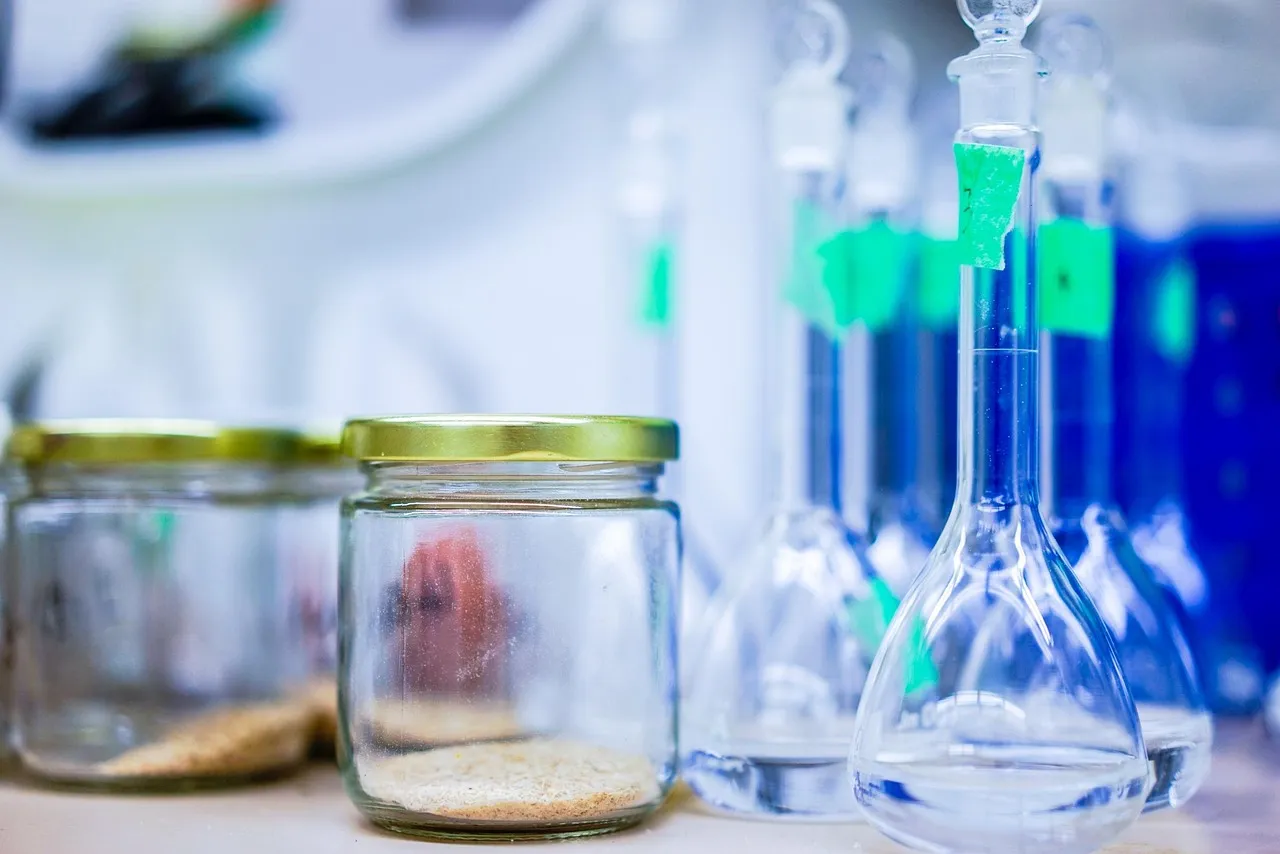 Gloved researcher labeling a multiple-dose vial in a laboratory