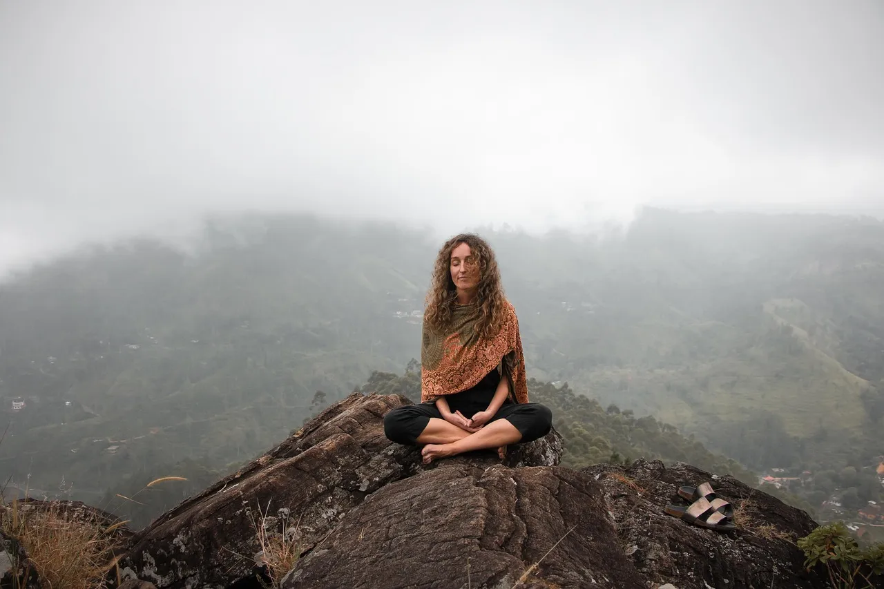 Person meditating outdoors in a peaceful natural setting, illustrating a calm parasympathetic state
