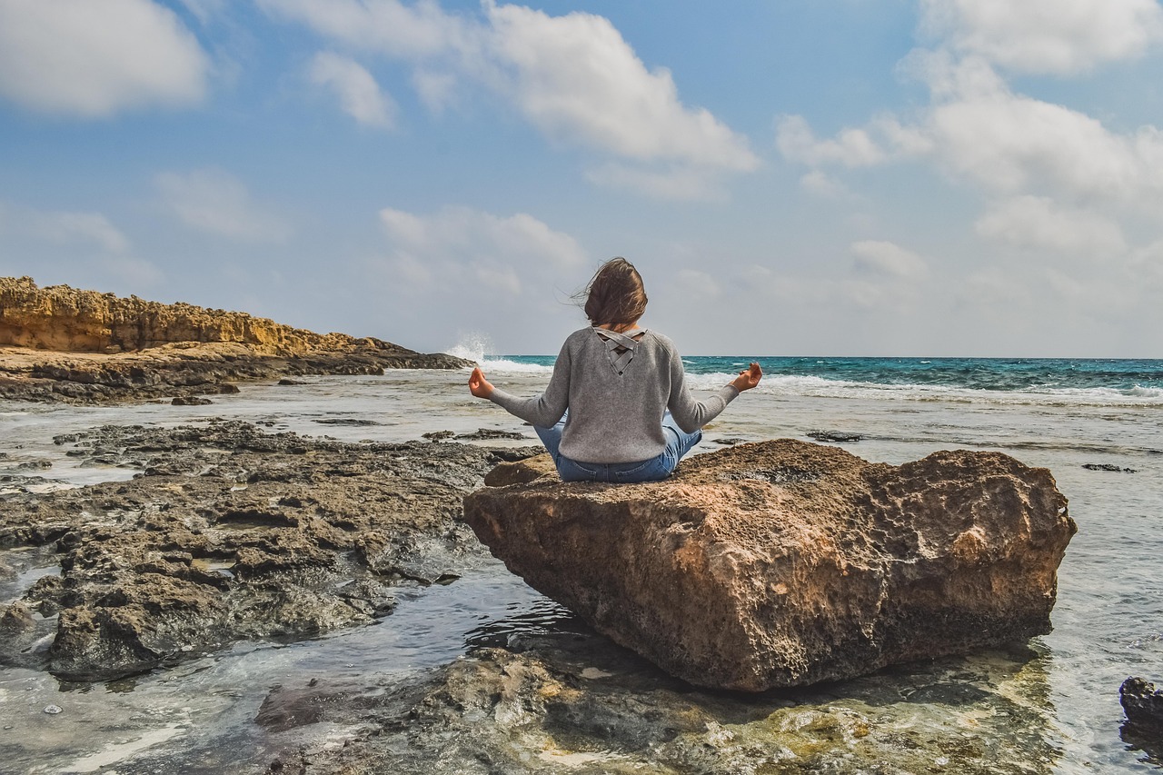 Person sitting quietly in nature practicing mindful breathing, reflecting the calming effect measured in mood studies
