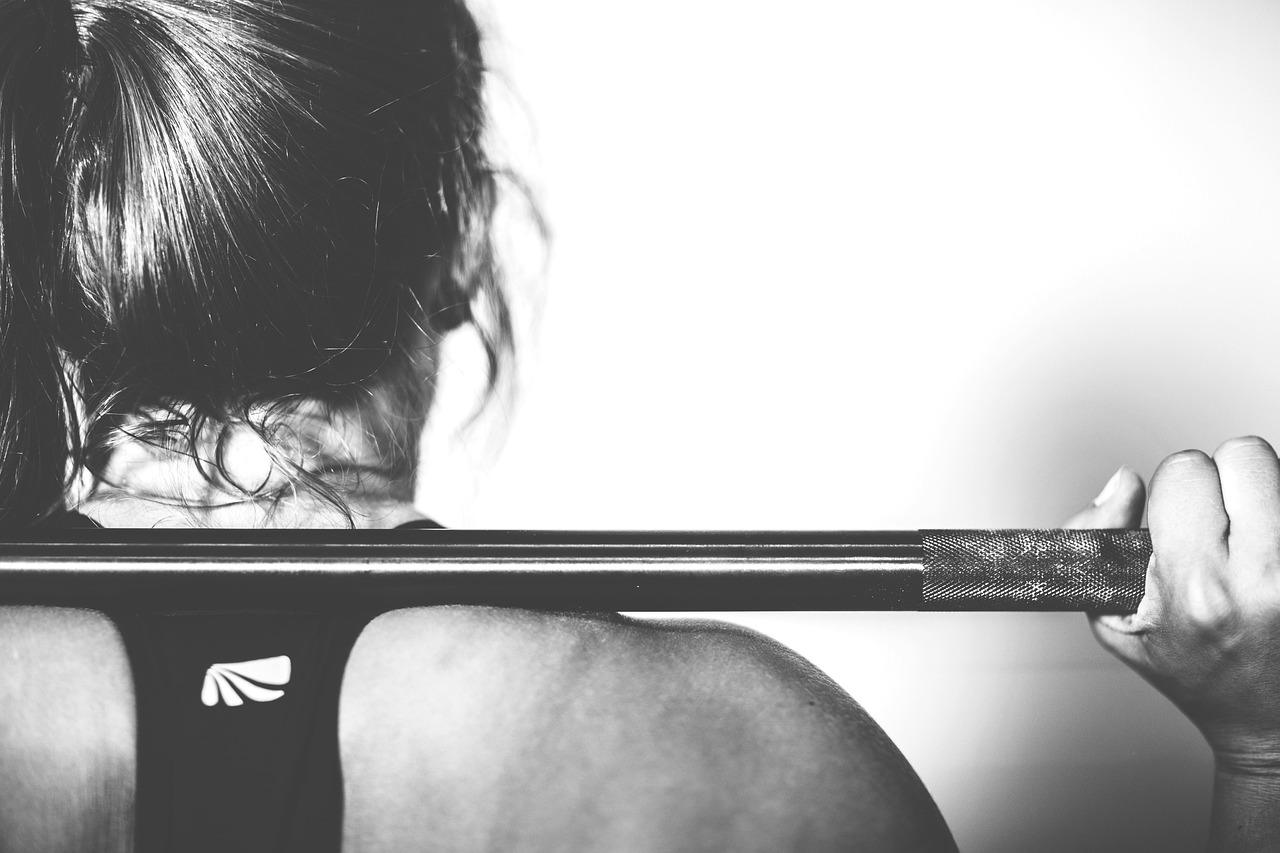 Athlete performing weighted strength training in a gym, representing repeated hard training sessions