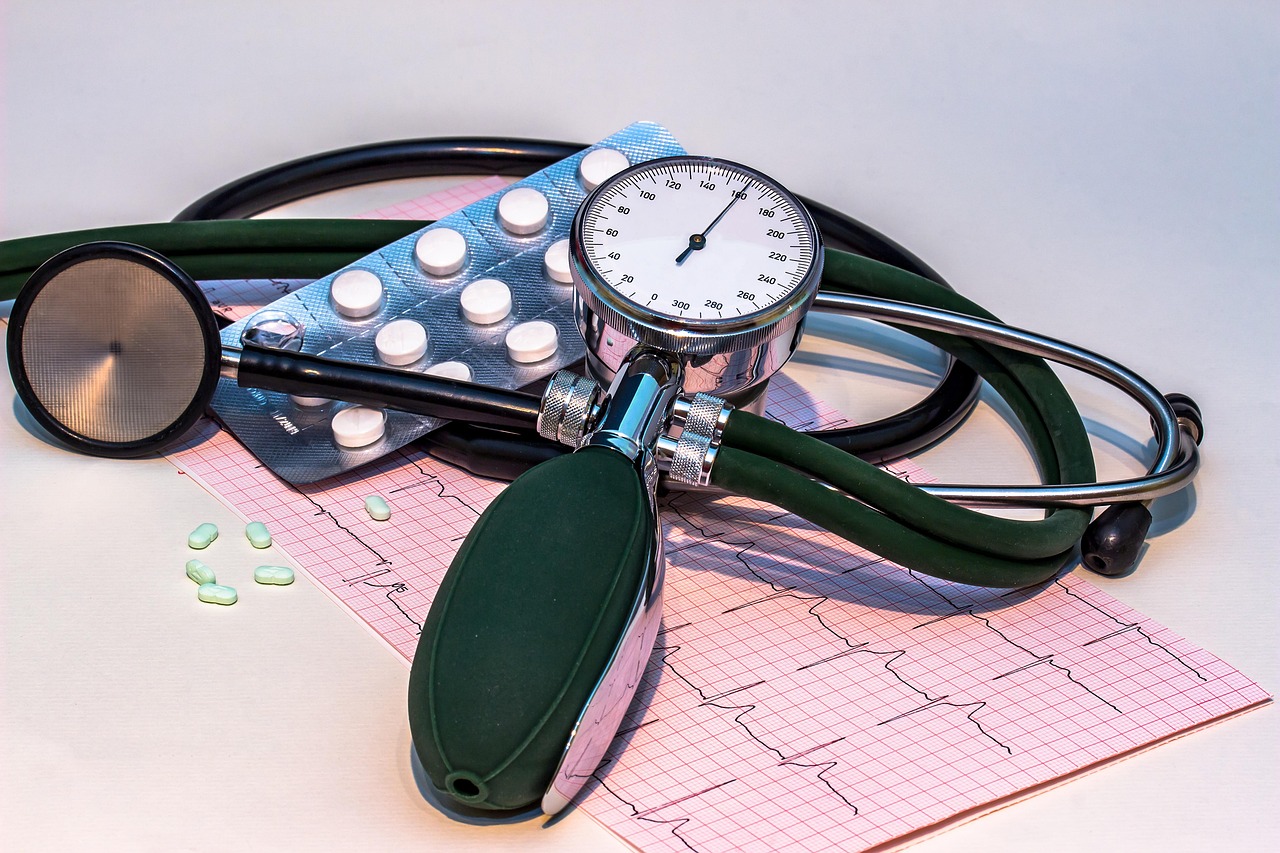A blood pressure monitor displays a heart rate curve alongside a stethoscope, illustrating the cardiovascular measurements used to assess risk
