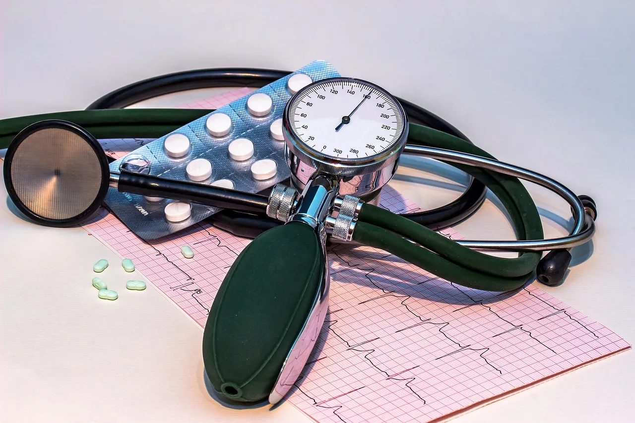 A blood pressure monitor displays a heart rate curve alongside a stethoscope, illustrating the cardiovascular measurements used to assess risk