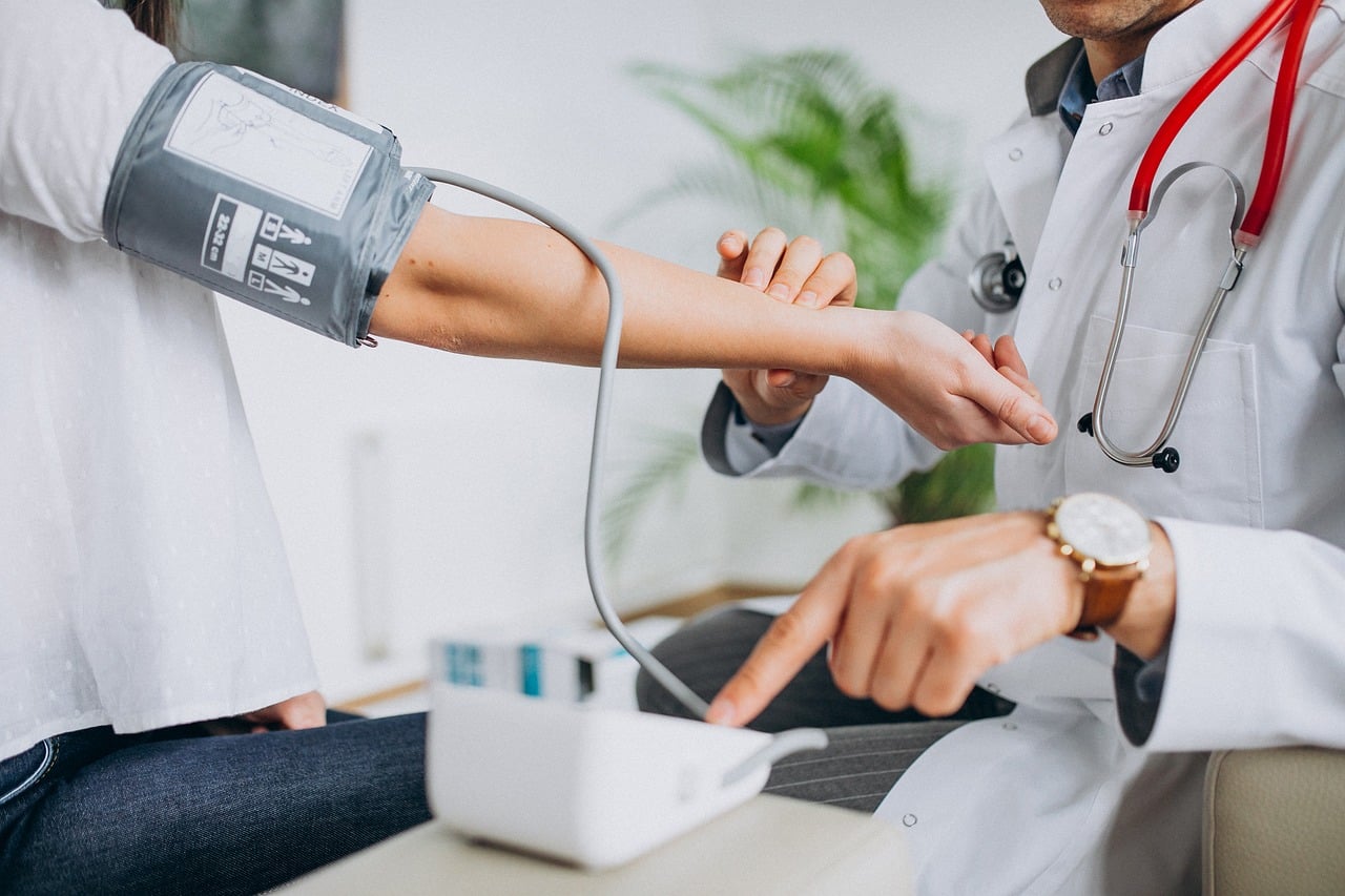 A cardiologist in a white coat discusses test results with a patient during a checkup, reflecting the kind of outcome data trials like SELECT are designed to produce