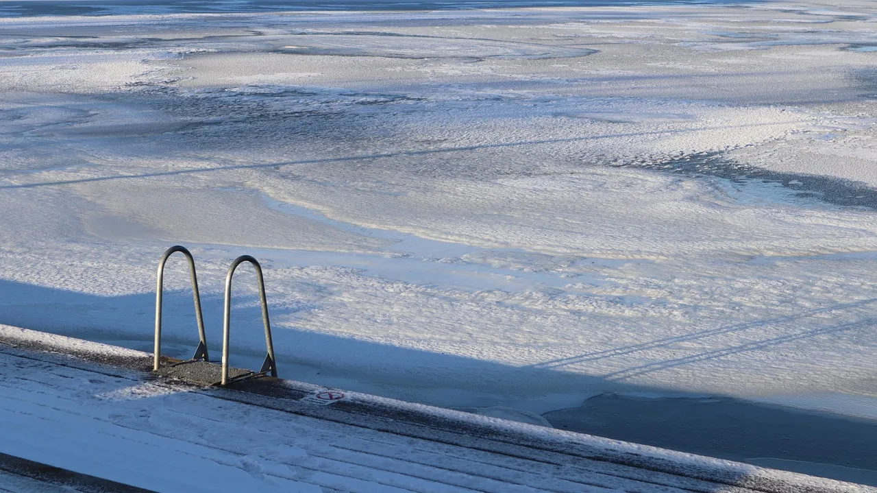 A frozen lake with a cleared opening for winter swimming, sunlight reflecting off the ice