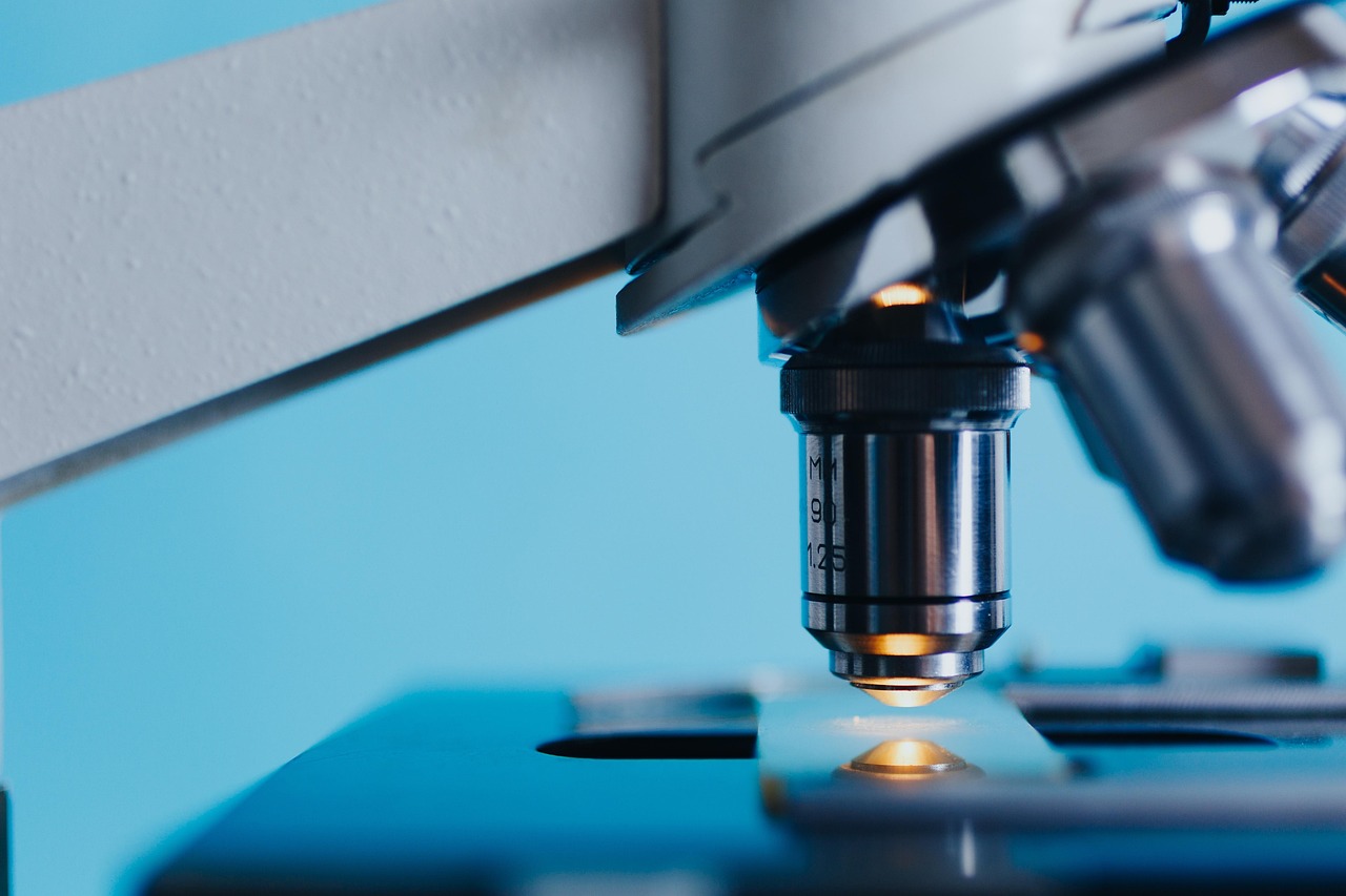 Close-up of a researcher examining a sample slide under a microscope in a laboratory setting
