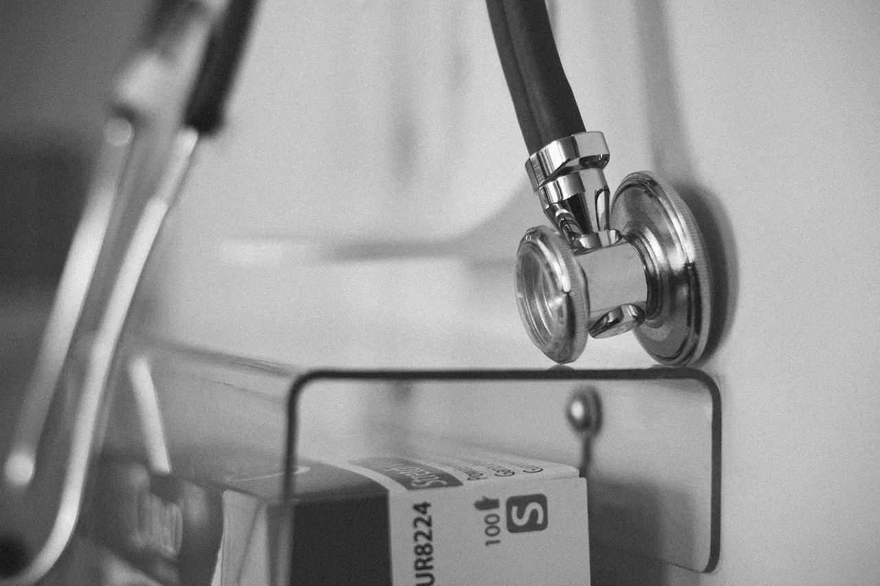 Doctor checking a patient's blood pressure with a stethoscope during a clinical exam