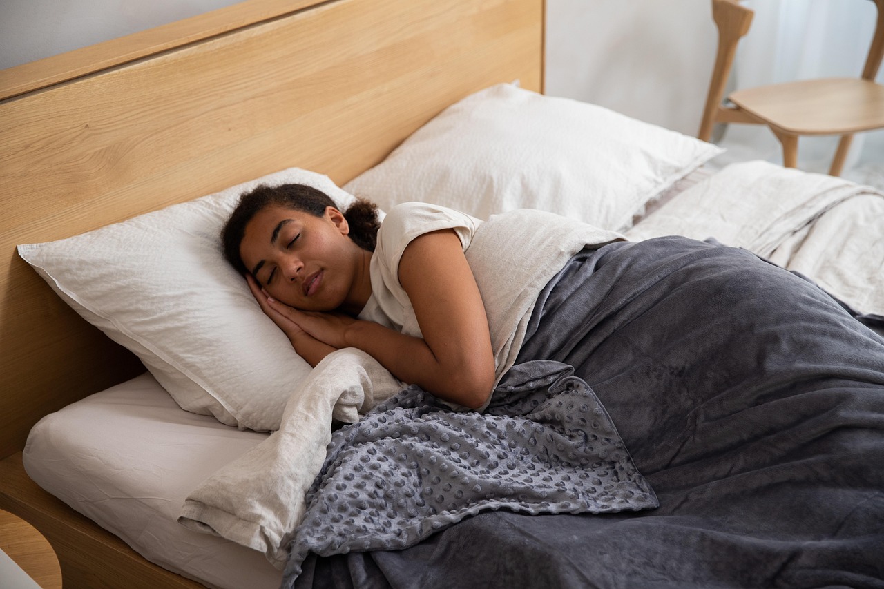 Woman, bed, blanket — illustrating Nutrition for Sleep: Carbs, Protein, and Timing