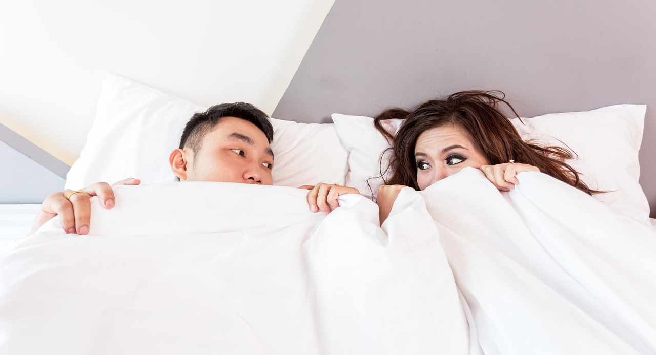 Happy valentines day, couple, lying — illustrating Sleep and Hormones: Testosterone, Cortisol, GH